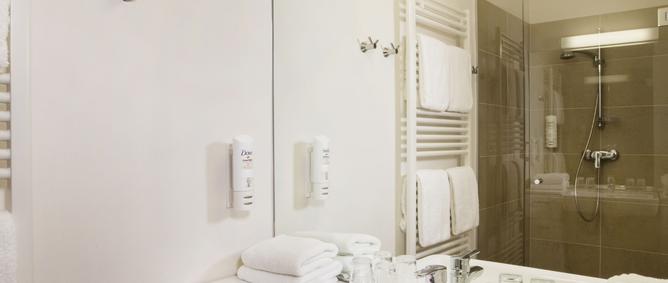 Blick ins Badezimmer mit großem Waschbecken und Spiegel